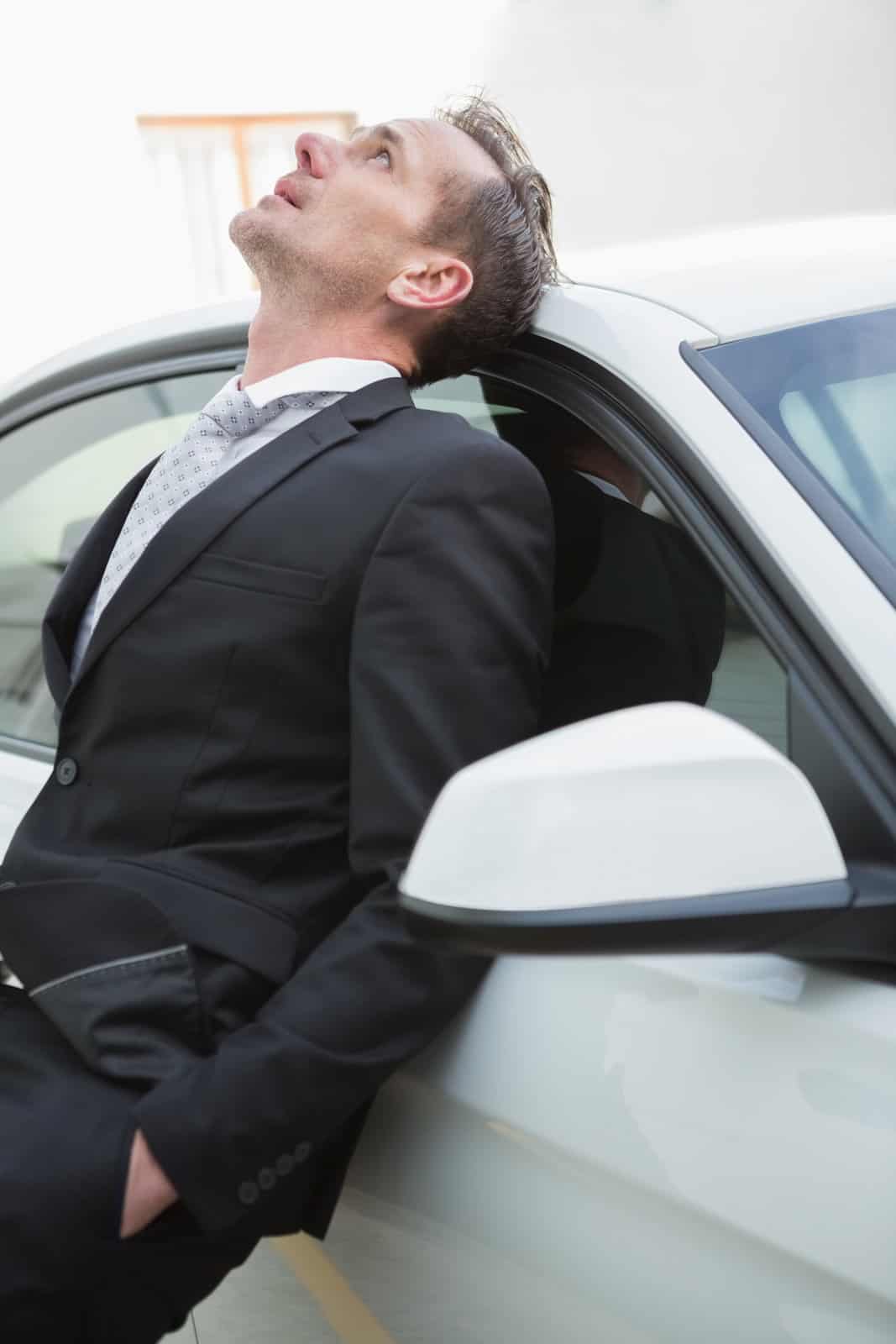 16763992_upset-businessman-leaning-on-his-car